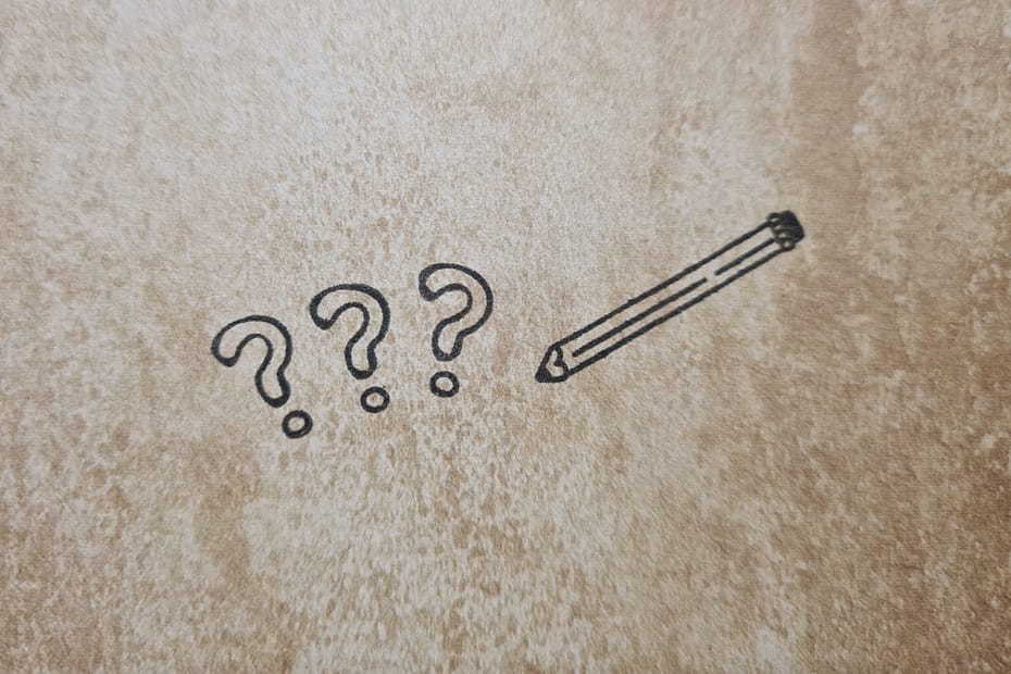 Symbolisch für sprachliche Zweifelsfälle und Verwirrung beim Schreiben wie sie auch durch die Frage wie oder als entstehen drei Fragezeichen und ein Stift